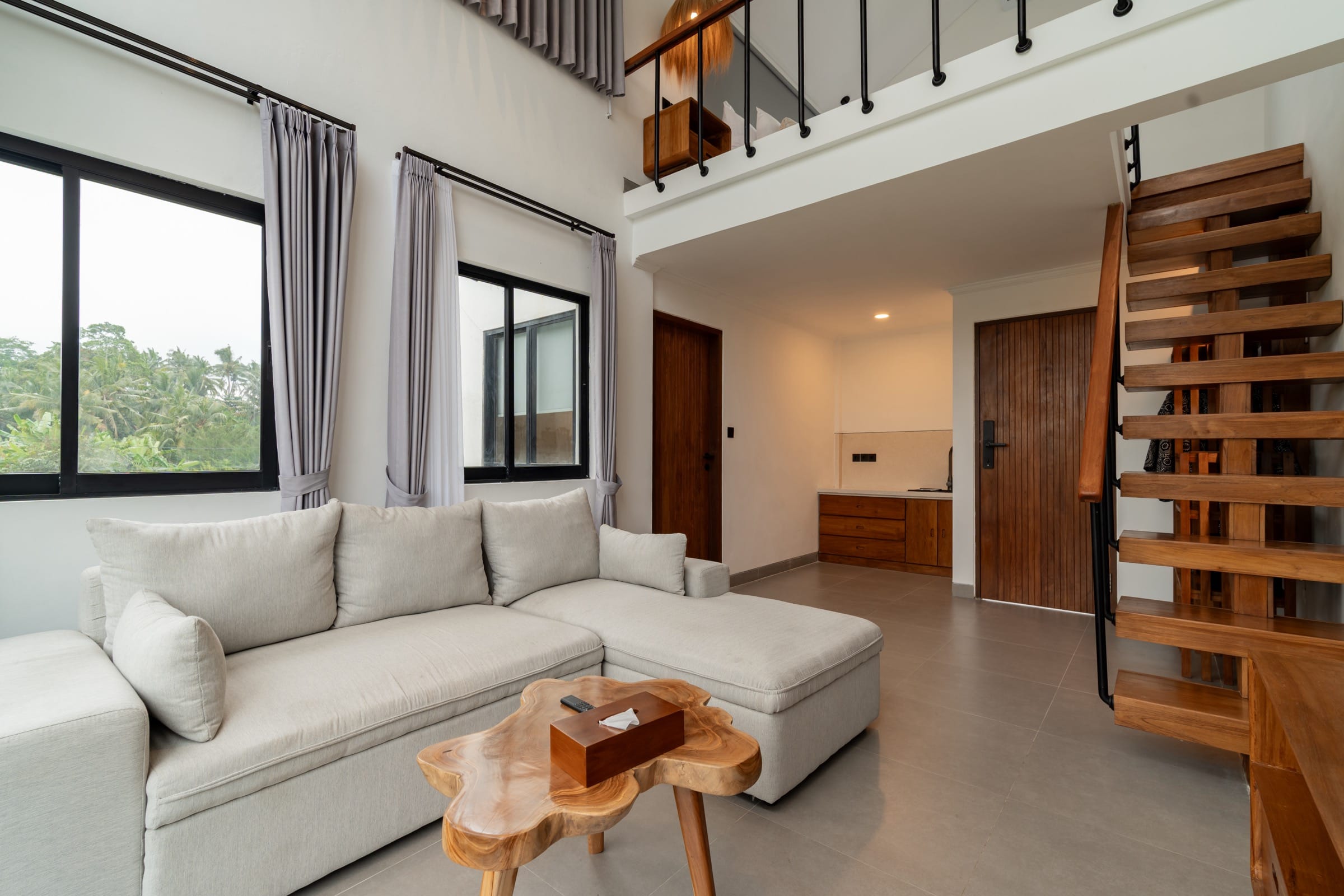 Living room with an open timber stair rising to the mezzanine
